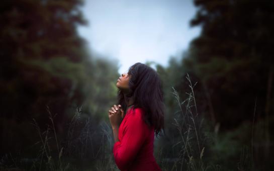 Black lady praying outdoors