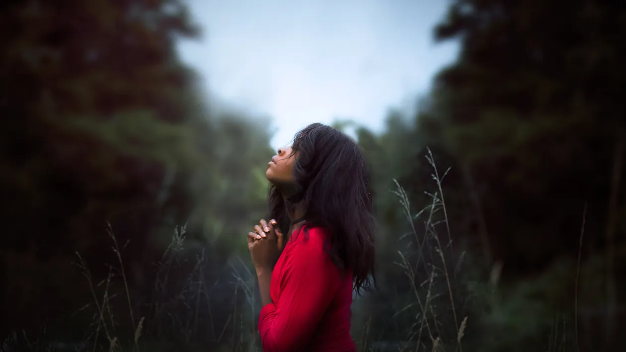 Black lady praying outdoors
